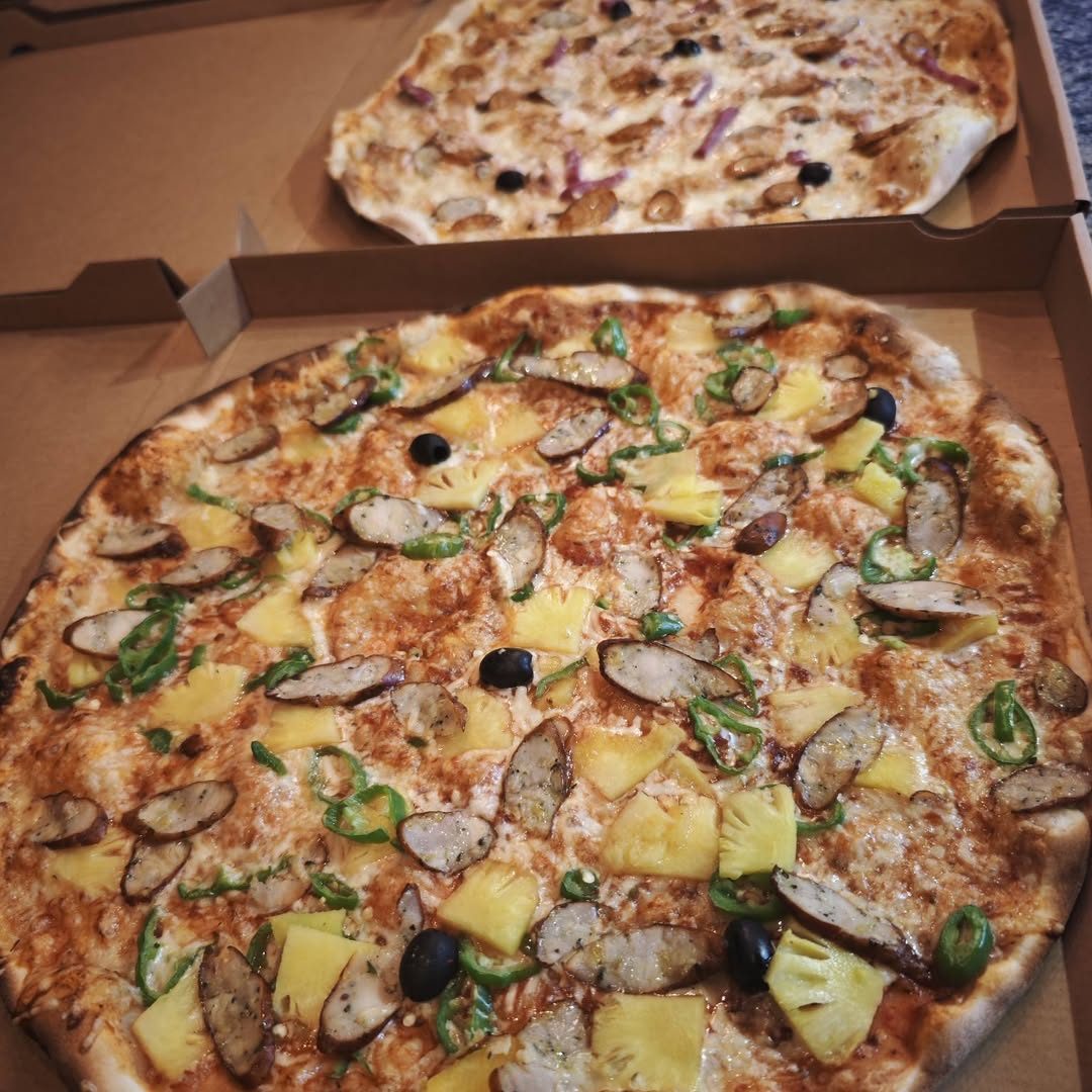 Pizza tropicale à l'ananas et piments verts dans sa boîte